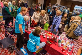 A group of people approaching a table-top sale